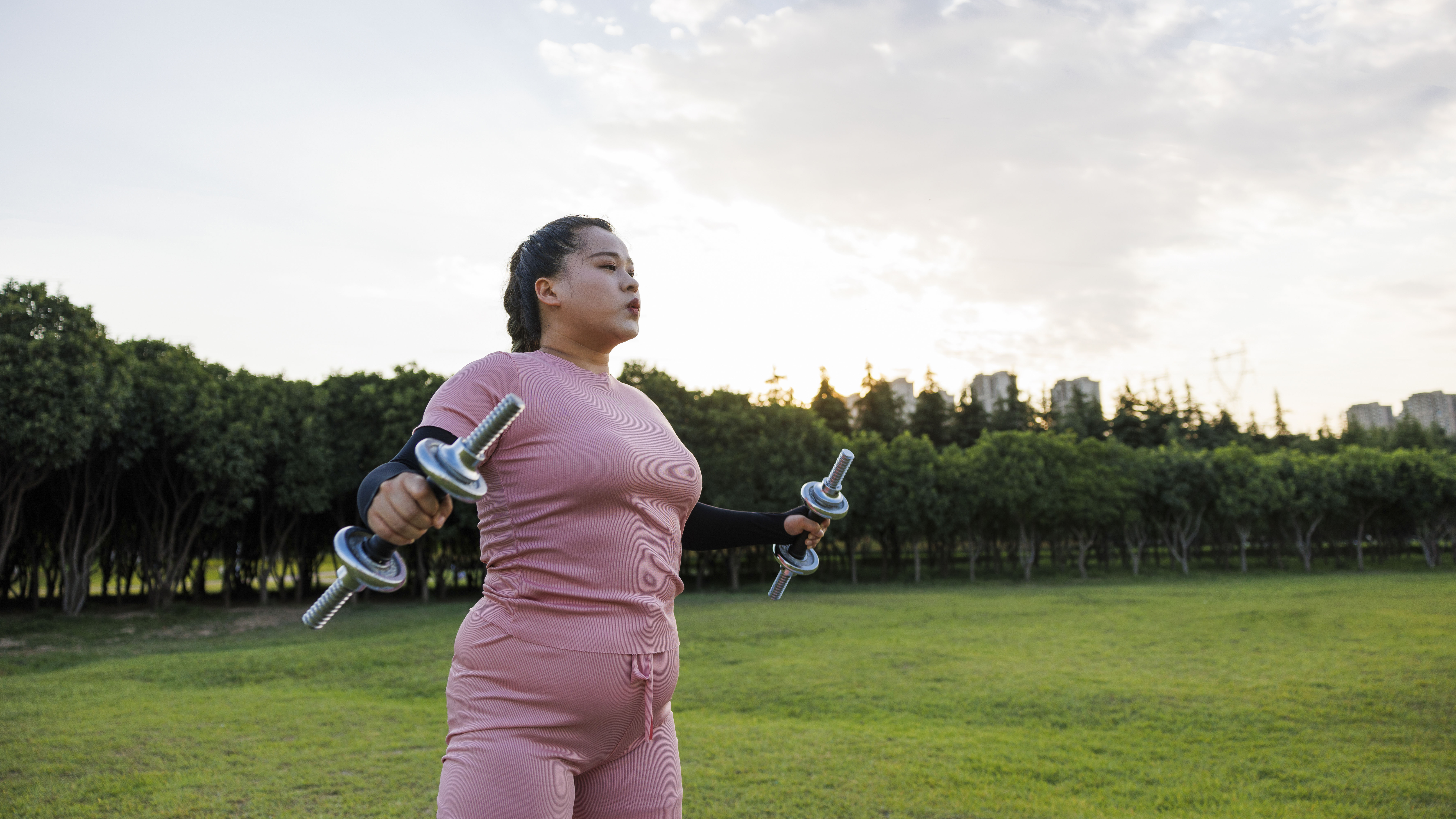 Mujer levantando pesas en el parque