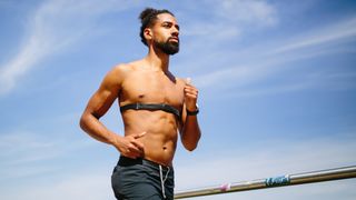 Man running with chest strap heart rate monitor