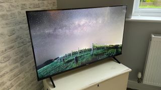 Hisense 43A6KTUK 43-inch TV. On the screen is an image of a vineyard under a starry night sky.