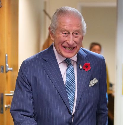 King Charles wearing a blue suit laughing