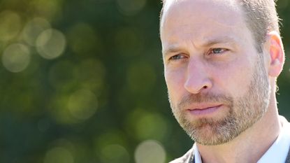 A headshot of Prince William wearing a white shirt and blazer looking thoughtful