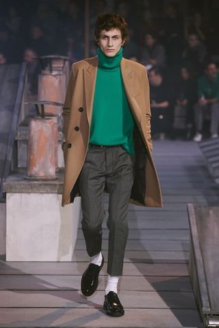 Model wearing overcoat, wide leg trouser, turtle neck sweater