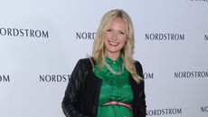 A photo of designer Emily Henderson in a green dress and black cardigan