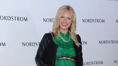 A photo of designer Emily Henderson in a green dress and black cardigan