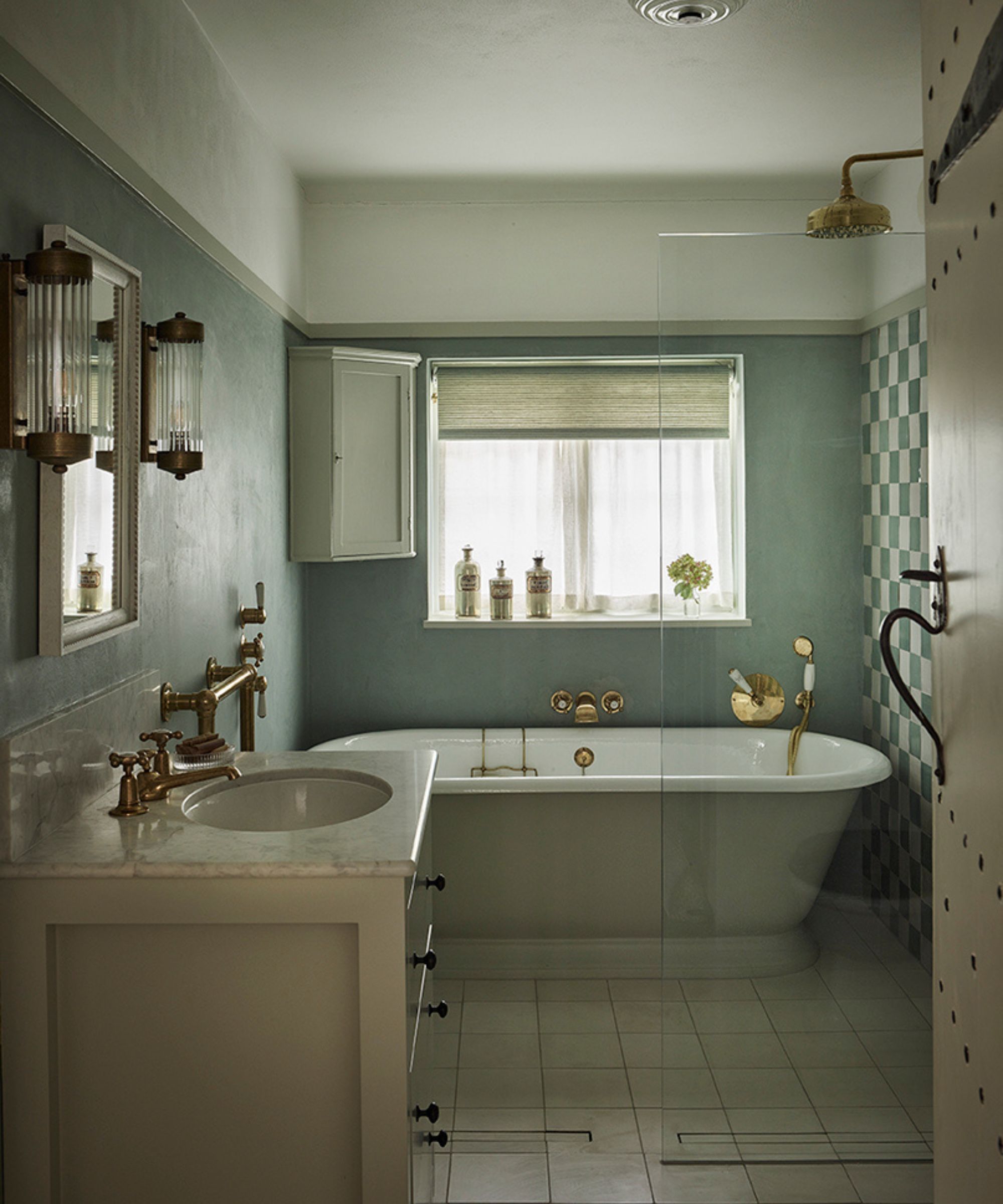 a soft blue bathroom in hampstead with checkerboard zellige tiles and a freestanding bath tub