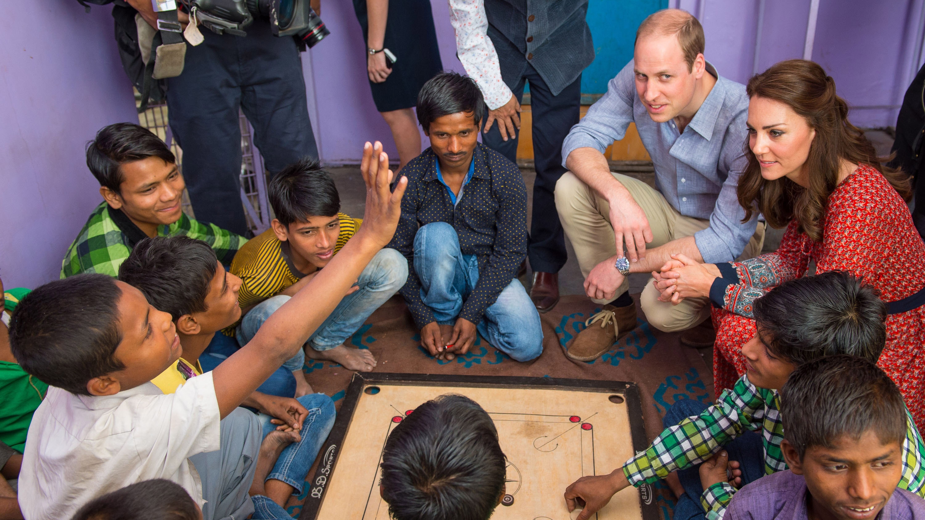 Catherine, Princess of Wales and Prince William play a game of carrom with children at a contact centre run by the charity Salaam Baalak at New Delhi railway station on April 12, 2016