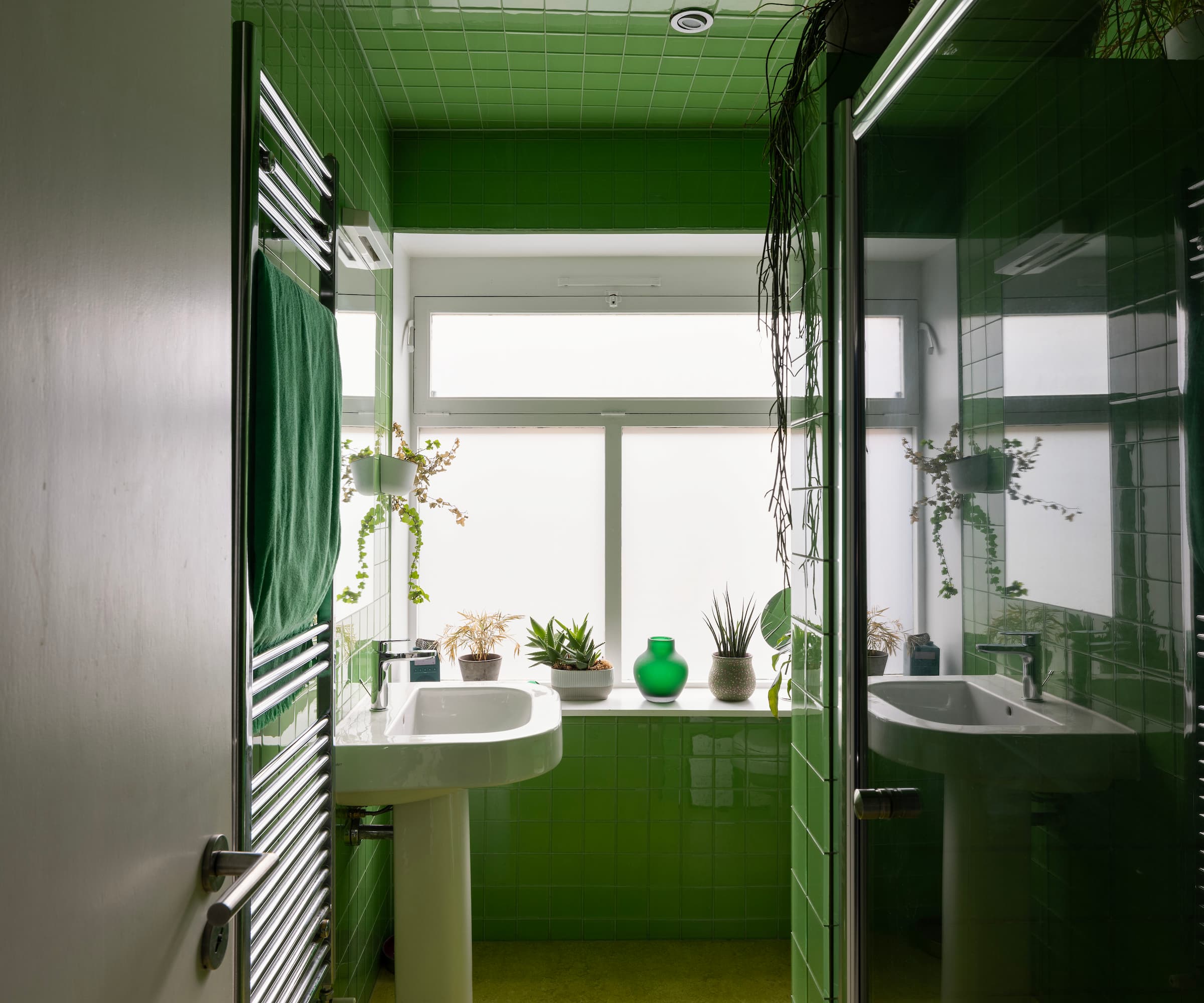 A green tiled bathroom and a walk in shower