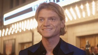 Matt Hagen smiling standing in front of theater during movie premiere red carpet in Clayface