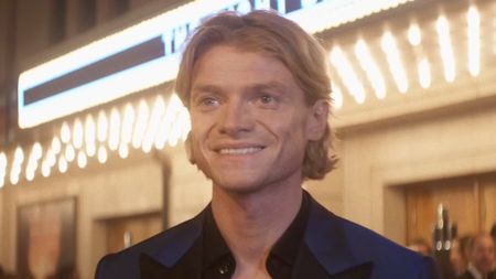 Matt Hagen smiling standing in front of theater during movie premiere red carpet in Clayface