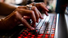 Ethical hacker concept image showing hands of a female pentester typing on a laptop keyboard.