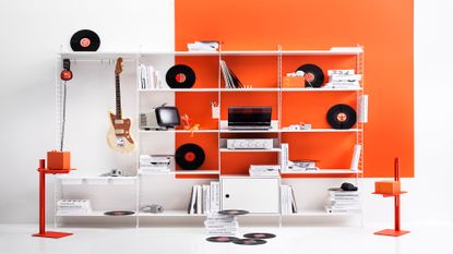 Record player stands String Furniture at Utility Design showing the shelving system against an orange and white wall