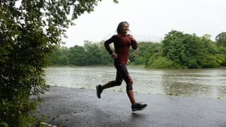 Woman smiling and running in the rain