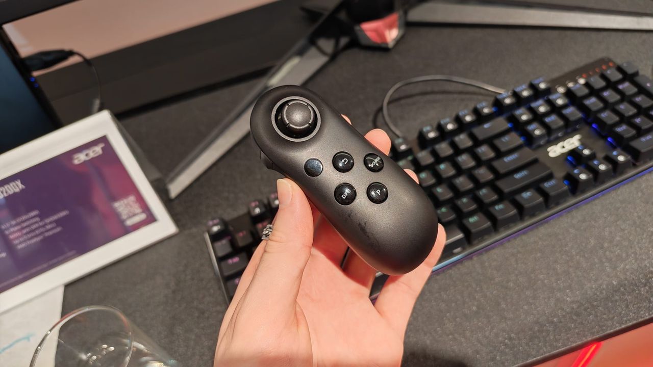 A reviewer holding the Acer Smart Dial