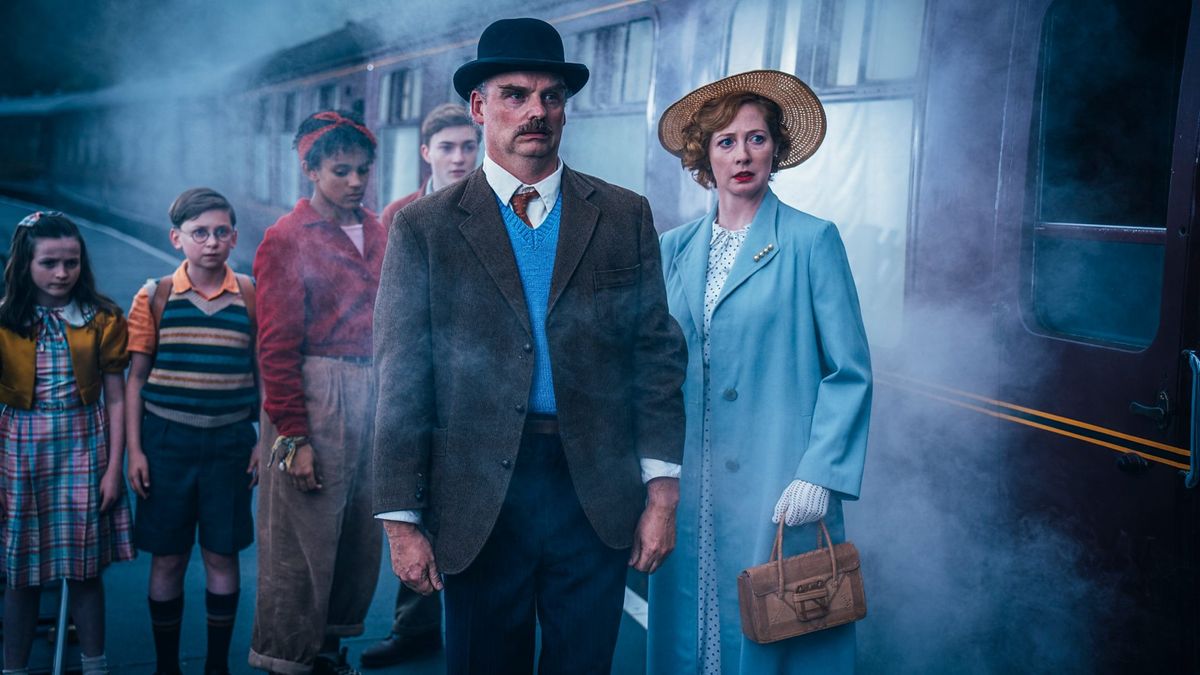 The Famous Five cast Roger (Henry Miller), Julian (Elliott Rose), George (Diaana Babnicova), Anne (Flora Jacoby Richardson), Petula (Orla Fitzgerald), and Dick (Kit Rakusen) on a train platform.