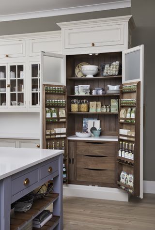 built in kitchen pantry with dark wood interior, white painted exterior, lilac kitchen island, wooden floor