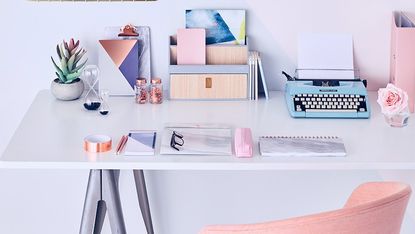 room with blue and white wall and desk with typing machine and armchair