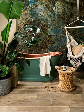 glamorous bathroom with green bath and botanical wall tiles