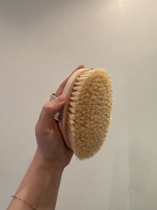 Mica Ricketts holding Aromatherapy Associates Polishing Body Brush