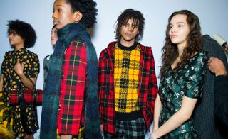 Models are dresses in red and yellow tartan sweaters and jackets, matched with tartan trousers and skirts