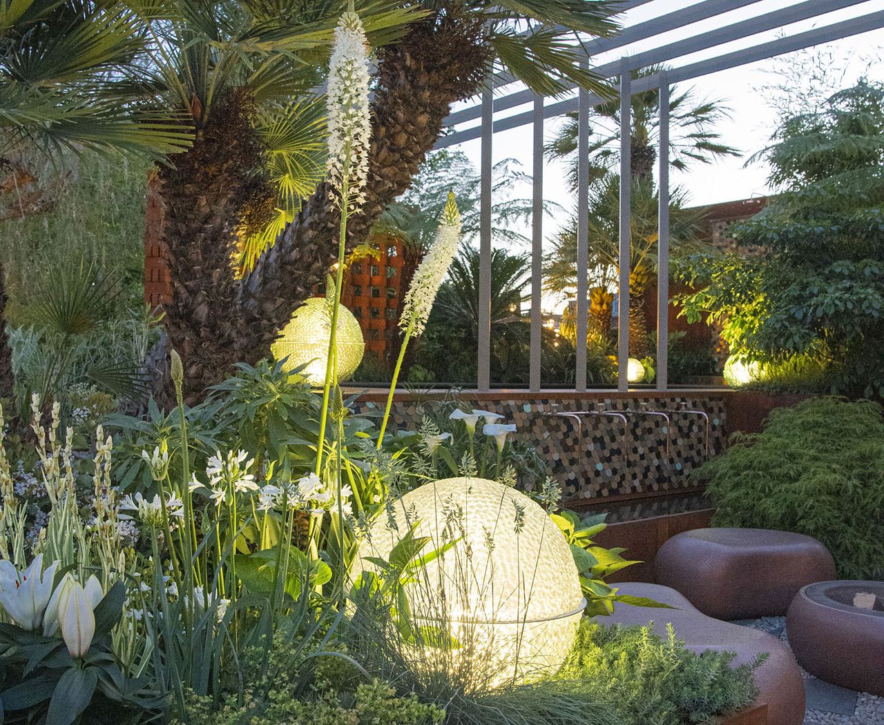 lit round garden sculpture in a green flower bed