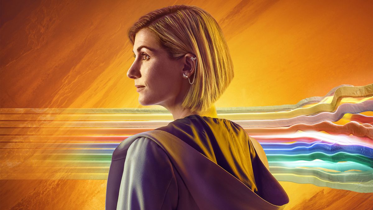 Jodie Whittaker as the Doctor in &#039;Flux&#039; - a profile shot of the Doctor in front of an amber background with a rainbow-coloured stripe behind her rupturing as it approaches the right margin