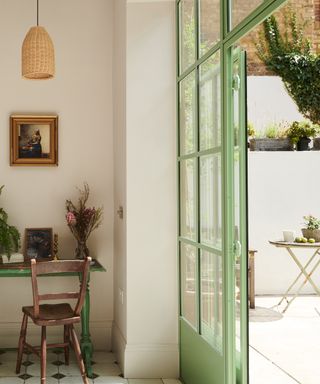 kitchen with dark green kitchen island, desk, mint green crittall window and doors