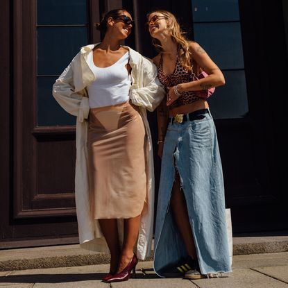 two fashion week attendees smiling at each other 