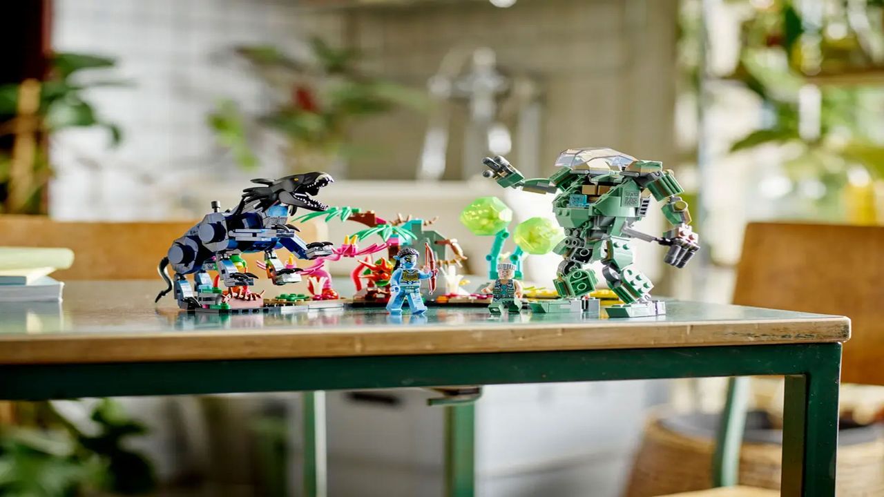 A brick-built animal with four legs, a brick-built mech suit of armor and some minifigures are displayed on a wooden table with plants in the background.