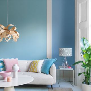 blue living room with off centre stripe and white sofa
