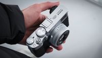 Man holding a Fujifilm X100 VI compact camera in one hand