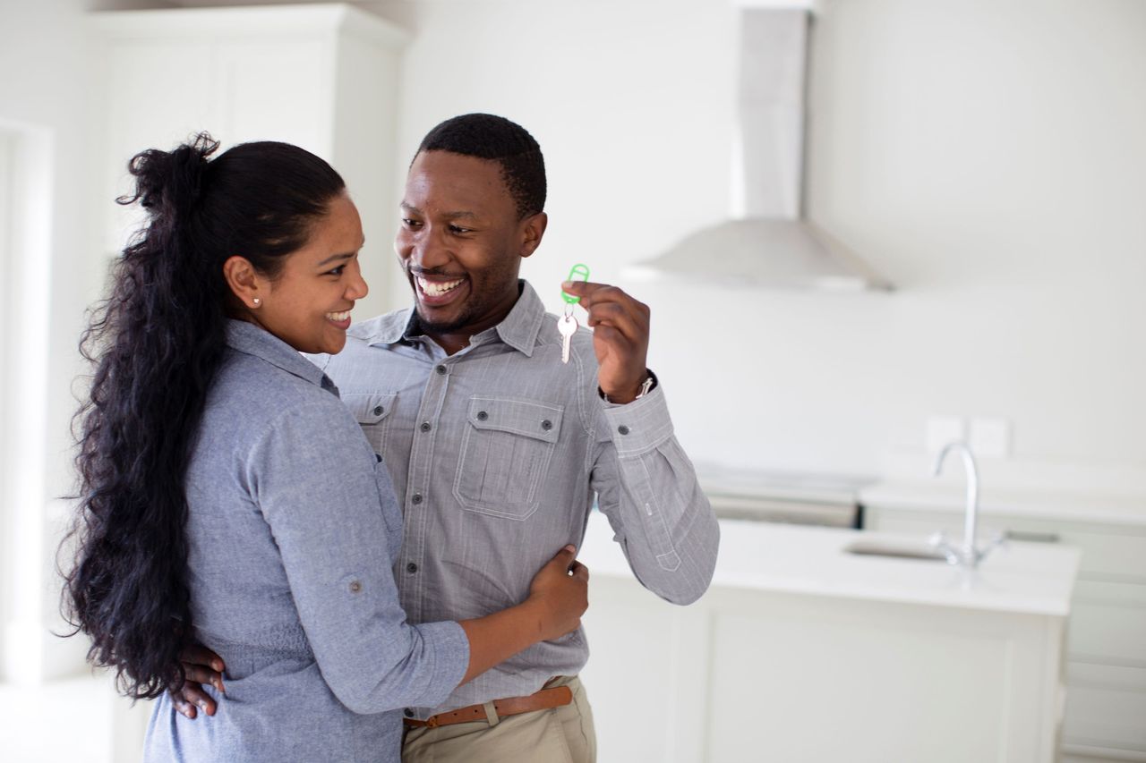 A happy couple holds the keys to their new home. 