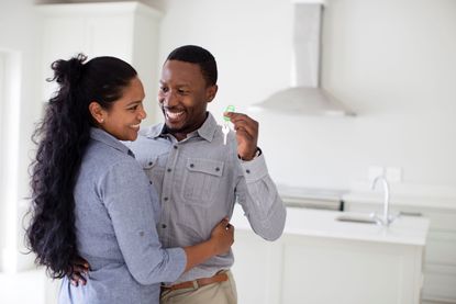 A happy couple holds the keys to their new home. 