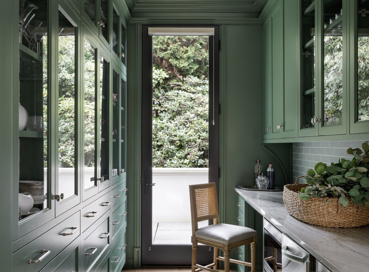 A galley kitchen that&#039;s painted dark green