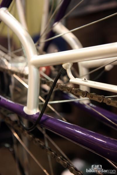 Yipsan nicely combines the rear derailleur exit port and the rearmost mounting point for the chain guard on this townie.