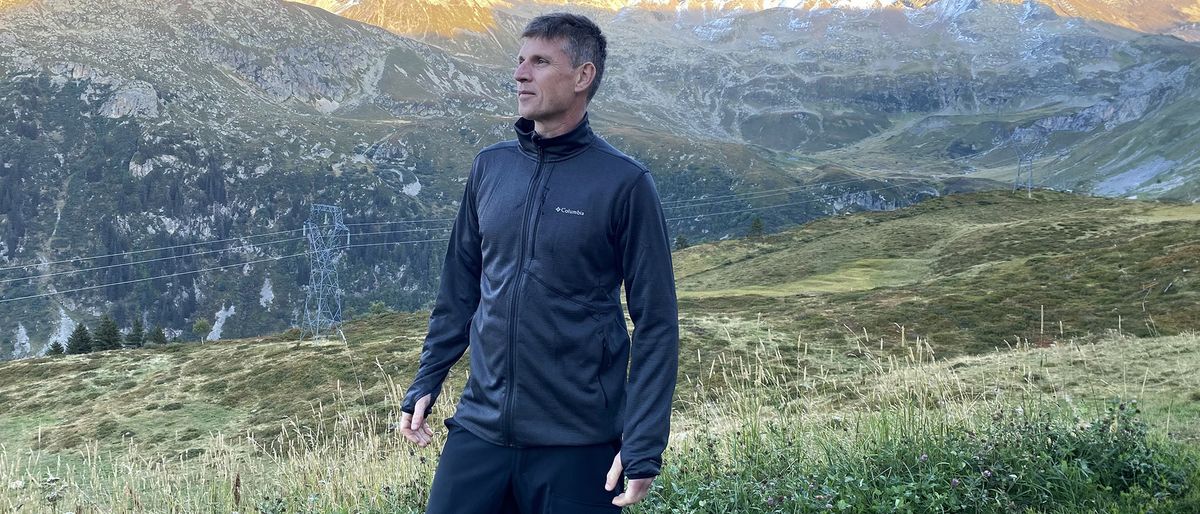 A man stands in the mountains wearing a black Columbia Park View Fleece