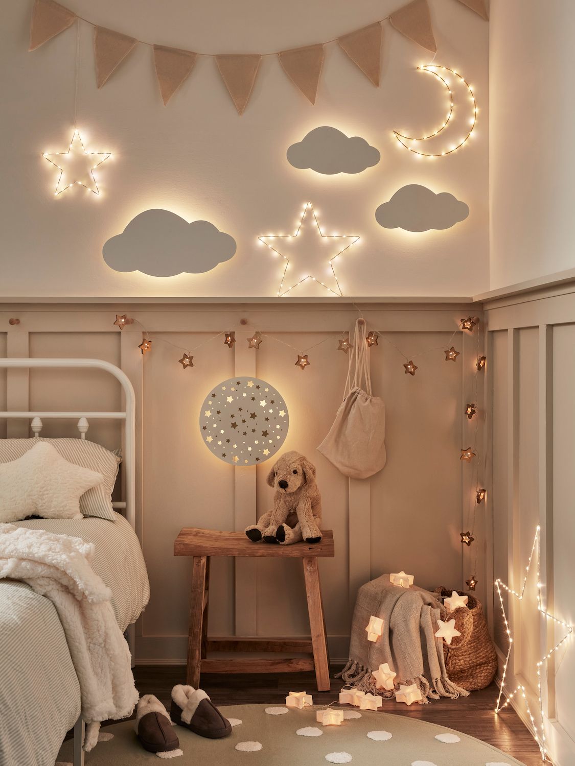 A child's bedroom with half wall panels and layered lighting, including string lights and wall mounted lights