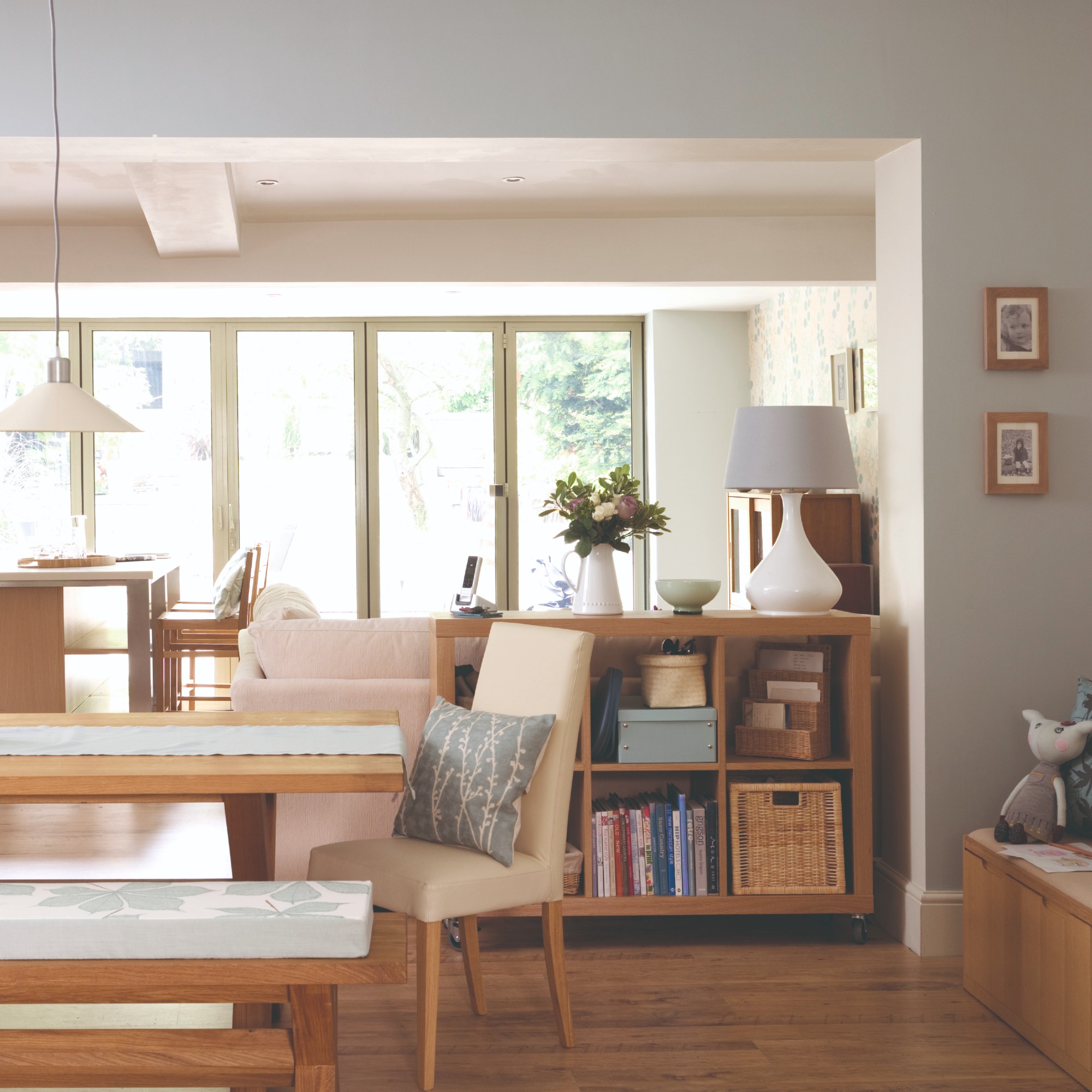 An open-plan living room connected to the kitchen and the dining area with a cube storage bookcase and a toy storage box to the side