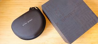 A pair of black Edifier Stax Spirit S3 headphones on a wooden desk