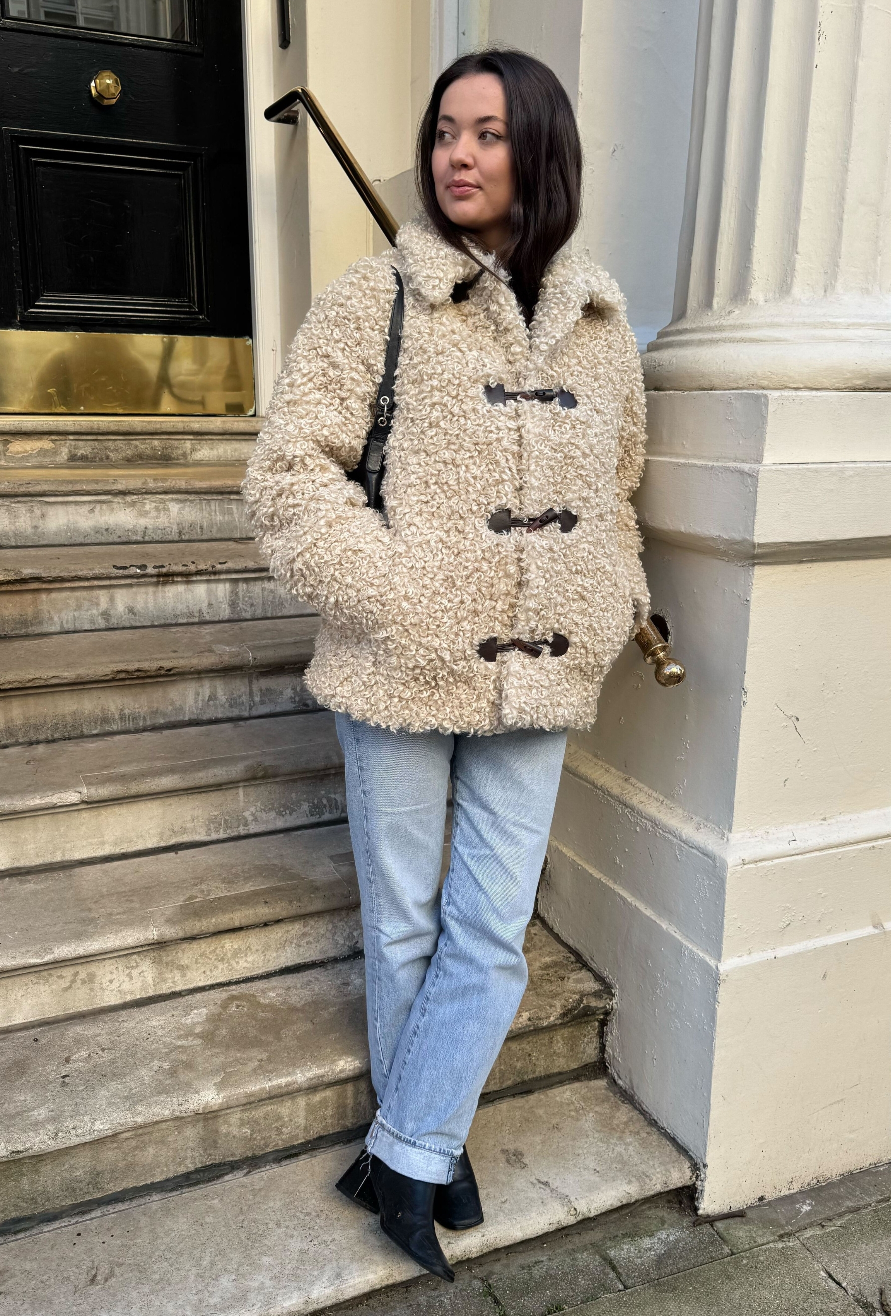 An editor from Who What Wear UK modelling a teddy coat