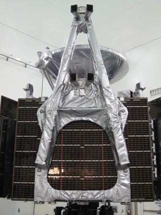 The Juno spacecraft, folded up and awaiting encapsulation in the rocket fairing. The 13-foot-long magnetometer boom, wrapped in bright thermal blankets, is in the foreground atop a stack of folded solar arrays. One of the twin magnetometers is mounted in the middle of the boom, and the other is mounted at the outermost end. Next to each magnetometer sensor is a pair of rectangular hoods, or light baffles, peeking out from under the thermal blankets; these define the fields of view for the two star cameras, which determine the orientation of each magnetometer sensor with great accuracy.
