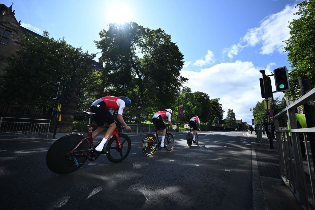 Riders from Switzerland pass the University of Glasgow as they take part in the Team Time Trial Mixed Relay road race during the UCI Cycling World Championships in Glasgow Scotland on August 8 2023 Photo by Oli SCARFF AFP Photo by OLI SCARFFAFP via Getty Images
