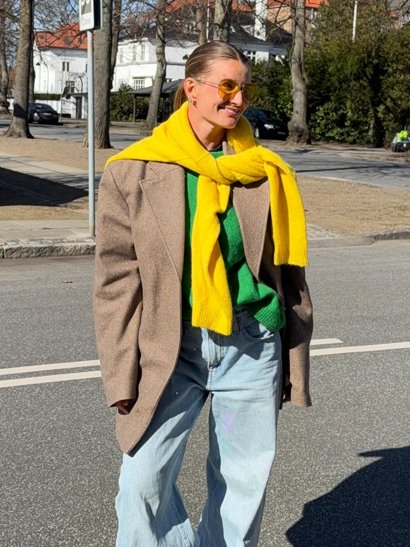 karo dall wears a green top, yellow jumper, blazer and baggy jeans