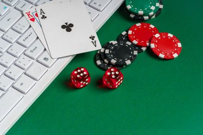 gambling green with poker chips, dice, cards, and a white keyboard