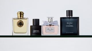 A variety of perfume bottles, some black, some clear, against a white backdrop