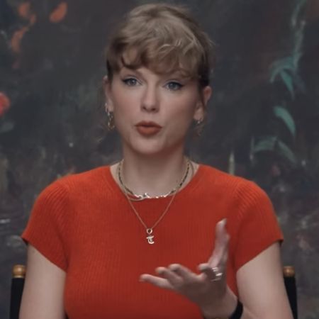Taylor Swift wears a Showgirl orange Reformation cashmere sweater