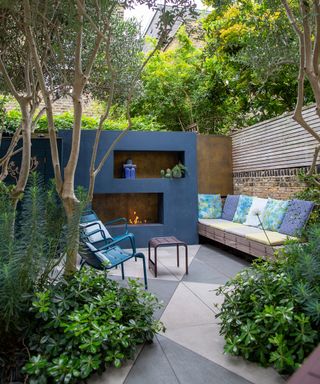 A blue color themed patio seating area with a built in fireplace and built in seating