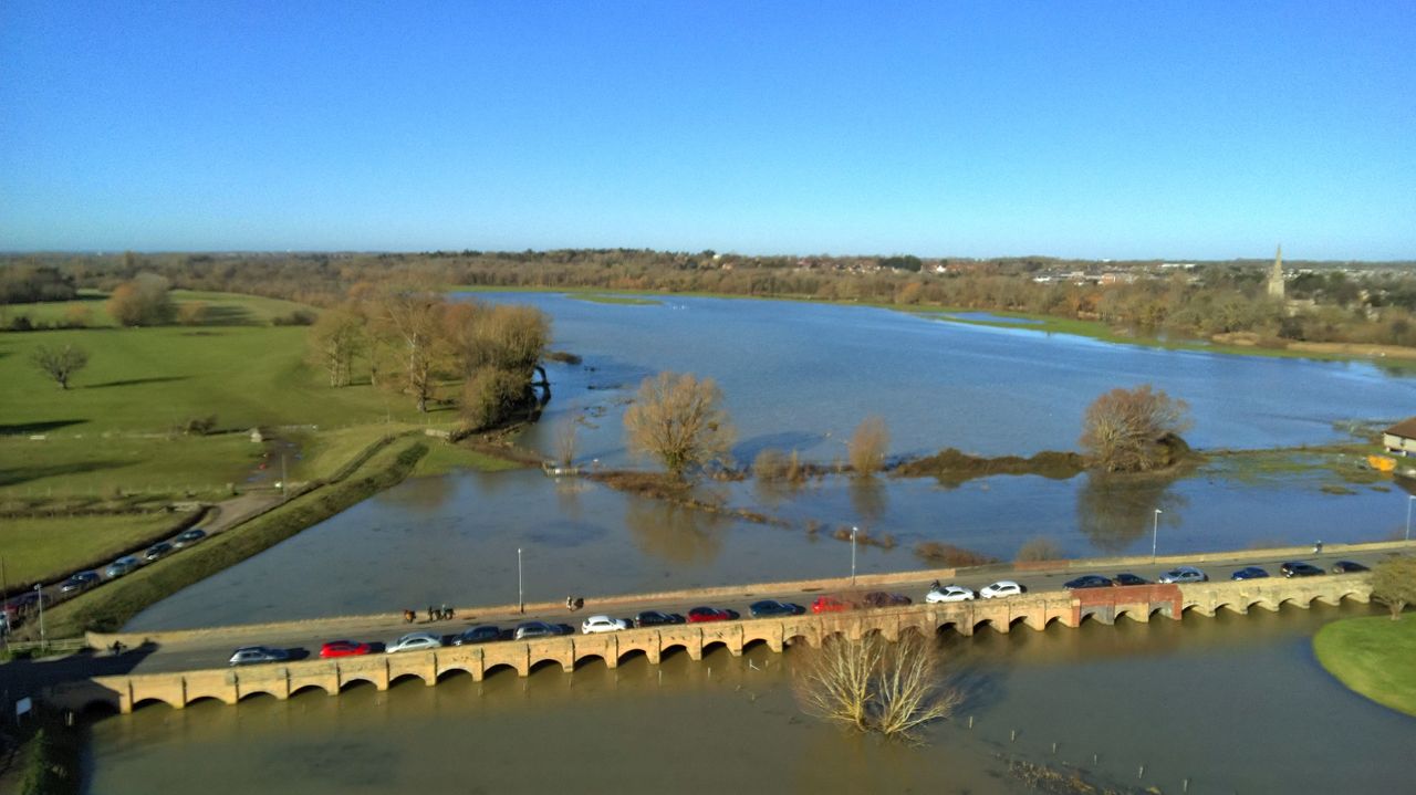 Bridge over a large river with cars crossing, as seen from the air, taken on a Ruko F11PRO 2 camera drone