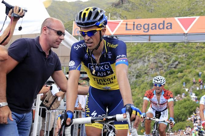 Stage winner Alberto Contador gets a helping hand from race director Giovanni Lombardi.