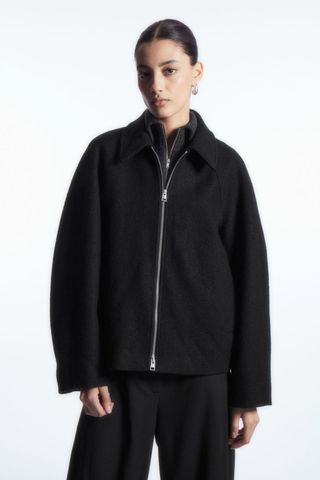 woman wearing oversized wool bomber jacket from the cos sale