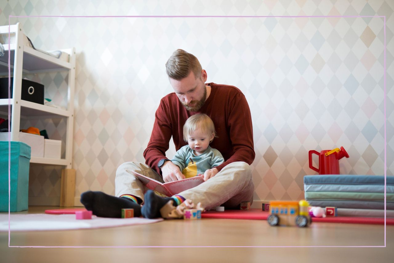 Dad sat on the floor playing with his child